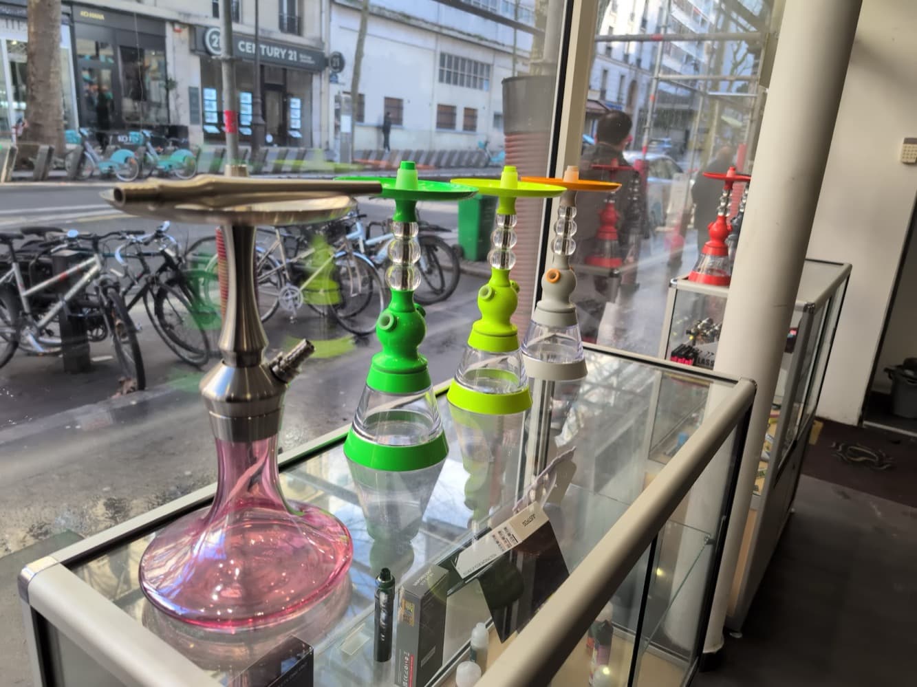 Des chichas colorées en vitrine, avec l’avenue Simon Bolivar et sa station Vélib’ en arrière-plan